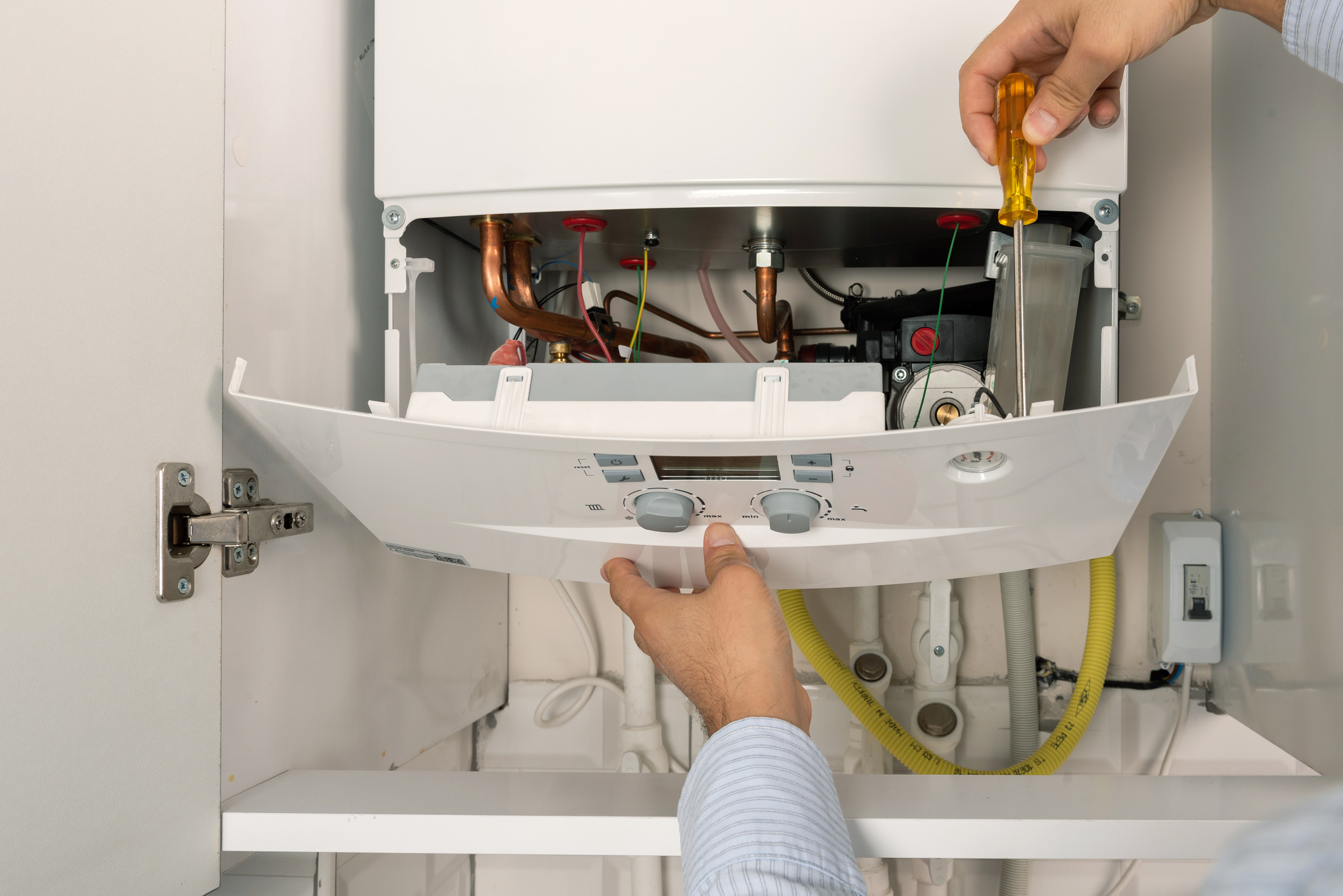 A technician performs maintenance on a boiler